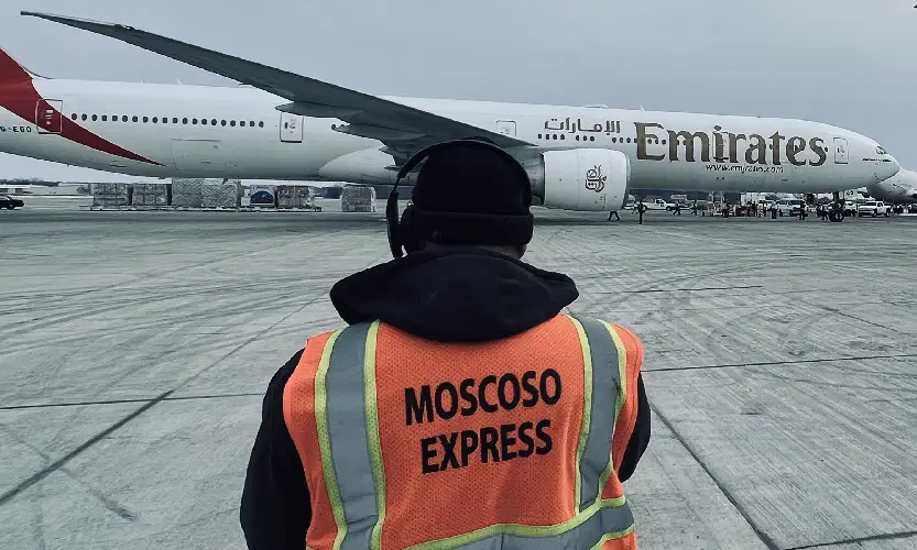Moscoso Express driver standing in front of an aircraft, showcasing expertise in air freight transportation and time-critical deliveries.